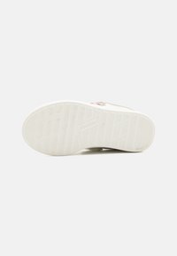 Hvit sneakersåle med teksturert grep mønster og logo. Rund form med en subtil glans, designet for grep og stabilitet.