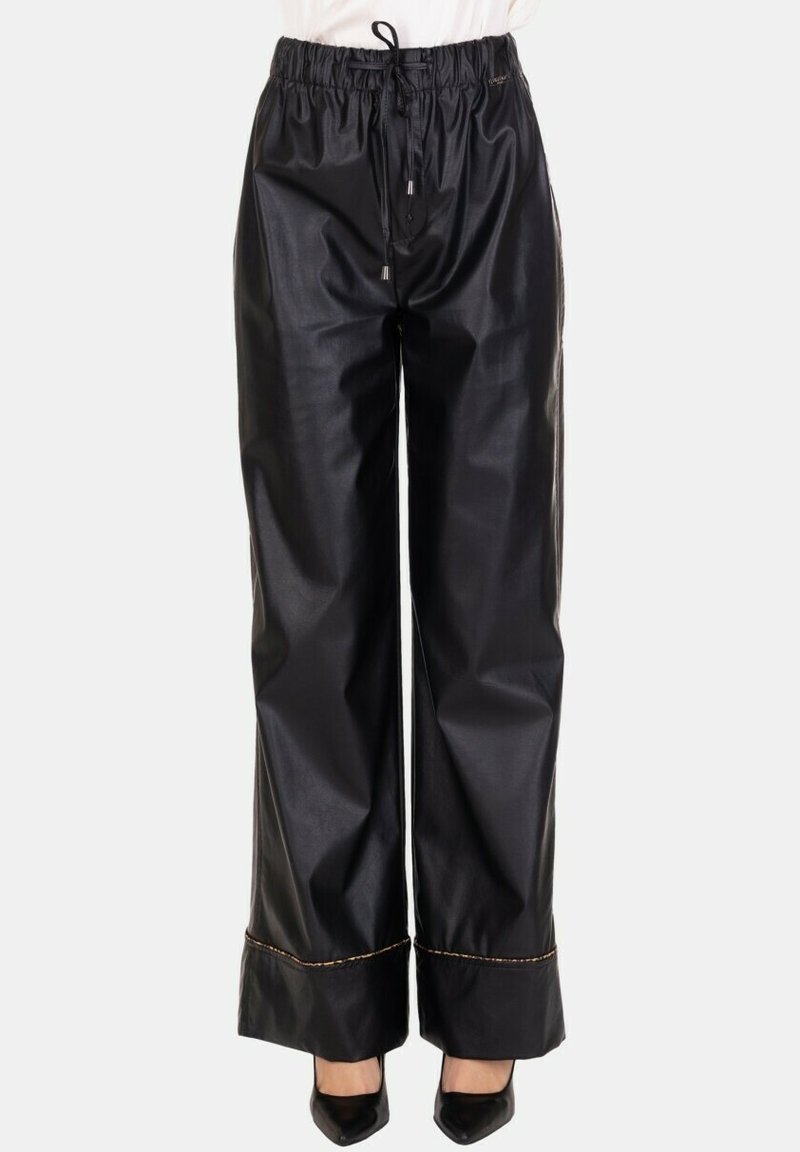 Pantaloni in similpelle nera con vita a coulisse, design a gamba larga e cuciture a contrasto all'orlo. Texture liscia, finitura lucida.