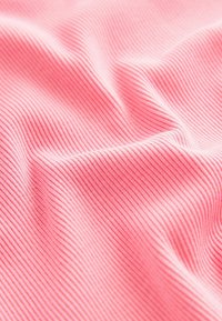 Tissu côtelé rose présentant des lignes texturées verticales, texture douce avec un léger éclat, idéal pour les vêtements ou les applications d'ameublement.
