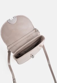 Kleine, glänzende beige Handtasche mit einem oberen Verschluss und verstellbarem Riemen. Innen verfügt sie über ein Hauptfach und eine Reißverschlusstasche. Keine äußeren Details.