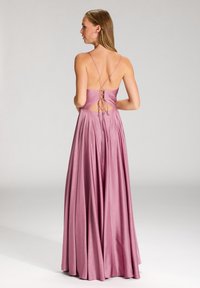 Langes, fließendes Kleid aus weichem rosa Satin mit tiefem V-Ausschnitt, Schnürdetail und dünnen Trägern, das eine glatte Textur und eleganten Fall aufweist.