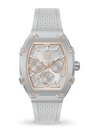 Orologio ottagonale dal tono argentato con un cinturino in silicone bianco testurizzato. Presenta dettagli in oro rosa, più quadranti secondari e un quadrante argentato scintillante.