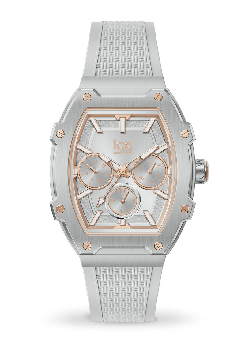 Montre octagonale argentée avec un bracelet en silicone texturé blanc. Présente des accents en or rose, plusieurs sous-cadrans et un cadran argenté scintillant.