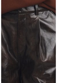 Brown leather trousers with a smooth texture, high waist, and tailored fit. Features a flat front and side pockets. Glossy finish accentuates design.