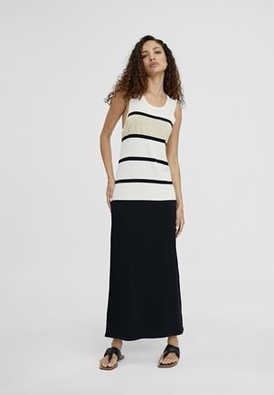 Vestido sin mangas con una parte superior blanca con rayas horizontales en negro y dorado metálico, que se extiende hasta una falda negra sólida, fabricado con una tela ligera.