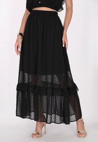 Schwarzer Maxi-Rock mit Punkten und einem Rüschensaum, aus durchsichtiger Stoff gefertigt, mit einem enganliegenden elastischen Bund und geschichtetem Design.