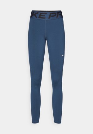 Laivastonsinisiä leggingsejä, jotka on valmistettu venyvästä kankaasta. Niissä on musta vyötärö, jossa on "NIKE PRO" -brändäys, sekä pieni valkoinen Nike-logo lahkeessa.