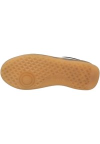 Suola delle scarpe con un motivo a diamante testurizzato, presenta un emblema circolare liscio, realizzato in gomma beige, che offre aderenza e durata.