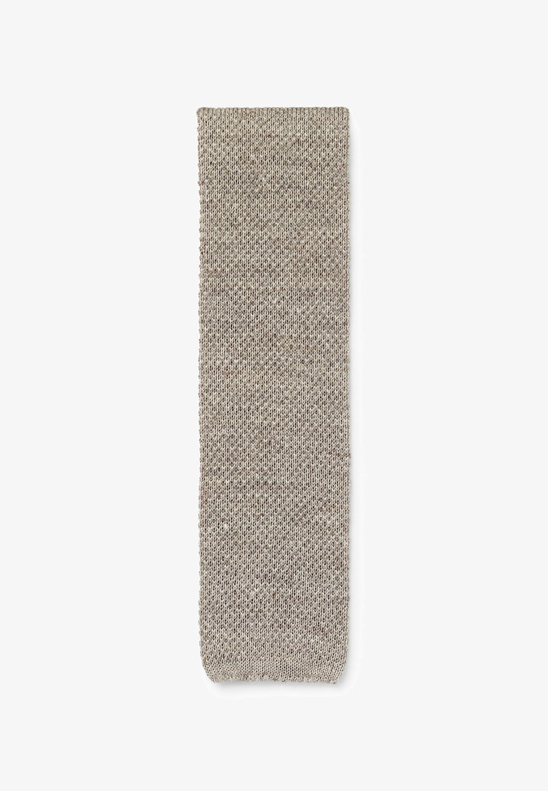 Longue écharpe rectangulaire beige tricotée avec un motif simple et texturé, affichée à plat sur un fond blanc.
