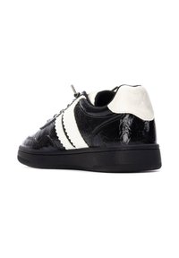Zapatillas de cuero en negro y blanco con un acabado texturizado, que cuentan con rayas blancas onduladas, suela de goma negra y un acento de talón liso.