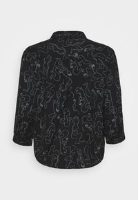Chemise noire à manches longues avec motif de visages et formes abstraits en ligne blanche continue, vue de dos.