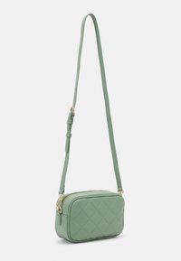 Green quilted faux leather crossbody bag with a rectangular shape, zip closure, and adjustable strap featuring gold hardware accents.