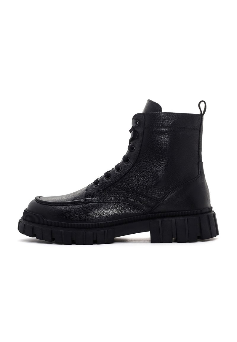 Botín alto de cuero negro con suela de goma gruesa y chunky y cordones en la parte delantera, diseñado para una moda resistente y durabilidad.