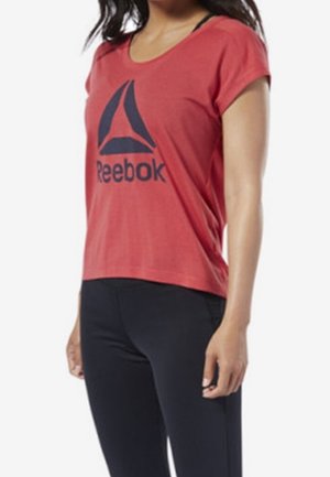 Kurzes rotes T-Shirt mit kurzen Ärmeln, das auf der Vorderseite ein dunkelblaues Reebok-Logo zeigt. Es besteht aus weichem Stoff und hat eine lockere Passform. Kombiniert mit schwarzen Leggings.