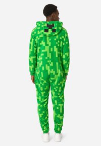Green fleece onesie featuring a pixelated design, hood with black square accents, and ribbed cuffs for a snug fit.