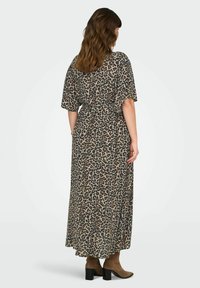 Leopardo rašto maxi suknelė, su trumpomis rankovėmis, prisiūta juosmeniui ir plazdančia sijonu. Pagaminta iš lengvo, tekstūruoto audinio.