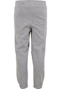 Pelēkie sporta bikses ar brīvu piegriezumu, elastīgu jostasvietu un kabošiem potītes. Iespējama viena kabata aizmugurē. Mīksts kokvilnas maisījuma audums.