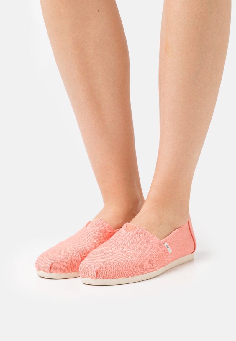 Rosa Stoff-Slipper mit strukturierten Oberflächen, runder Zehenpartie, elastischen Seitenpaneelen und einer weißen Gummisohle.