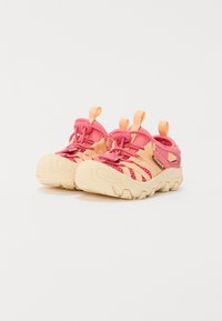 Chaussures en maille rose et pêche avec une semelle en caoutchouc texturé, dotées de lacets élastiques et de languettes pour un enfilage facile.