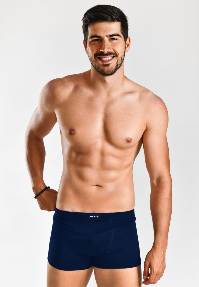 Boxer blu navy con cintura elasticizzata, caratterizzati dal logo "MAXTE"; il modello ha una corporatura muscolosa, è a torso nudo e si trova di fronte a uno sfondo semplice.