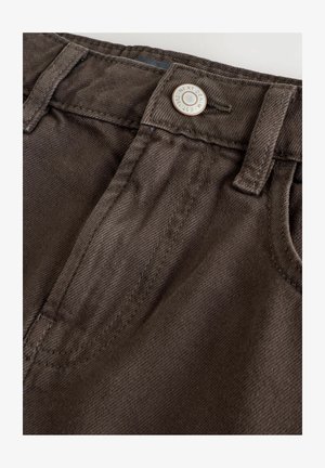 Brūni denimi bikses ar izteiktu auduma tekstūru, ar metāla pogu, jostas cilpām un klasisko piecu kabatu dizainu.