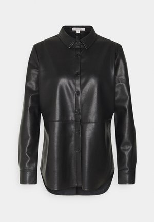 Zwart faux leren blouse met lange mouwen, knoopsluiting, kraag en een gebogen zoom, getoond op een simpele lichte achtergrond.