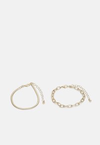 Ensemble de bracelets en ton or comprenant deux designs distincts : un bandeau flexible et élégant et un style en maillons de chaîne avec fermoir ajustable.