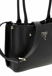 Borsa a tracolla in pelle nera con dettagli in metallo dorato, forma strutturata, doppi manici e un logo di marca triangolare sul davanti.