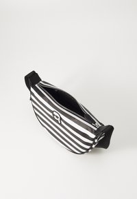 Riñonera a rayas blanco y negro con forma curva, cierre de cremallera y un destacado logo circular. Acabado suave y brillante.
