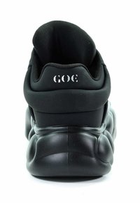 Czarne sneakersy z grubą, amortyzującą podeszwą i zaokrąglonym kształtem. Posiadają gładką powierzchnię oraz wyściełany, zaokrąglony kołnierz. Nazwa marki widoczna na pięcie.