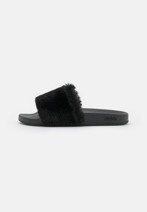 Sandale noire style slide avec bride en fourrure moelleuse et semelle texturée, vue de côté montrant le logo embossé "BOSS" sur le talon.