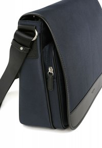 Borsa messaggera navy con corpo in tessuto testurizzato, dettagli in pelle, tasca frontale con zip e tracolla regolabile.