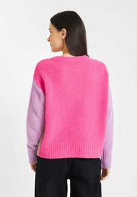 Gebreide trui met een ronde halslijn, voorzien van een felroze lijf en lichtpaarse mouwen. Ribgebreide manchetten en onderzoom met een gestructureerde afwerking.