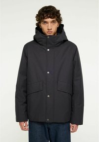 Svart, huva jacka med en mjuk textur, tryckknappar och två framfickor; designad med en avslappnad passform och minimalistisk stil.