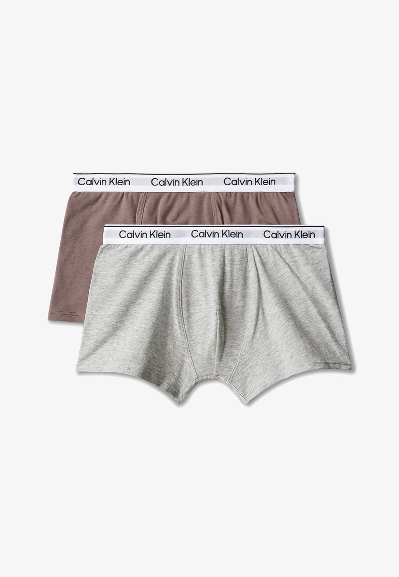 Δύο ζευγάρια ανδρικά boxer Calvin Klein, ένα σε ανοιχτό γκρι και το άλλο σε καφέ, και τα δύο με λευκές ελαστικές μέσης και λογότυπα της μάρκας.