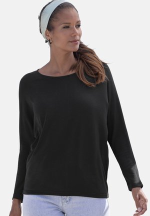 Schwarzes Langarmshirt aus weichem Stoff mit rundem Halsausschnitt. Glatte Textur und lockere Passform, kombiniert mit einem hellblauen Haarband.