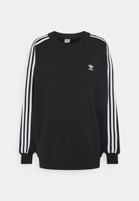 Sweatshirt noir avec un col rond, des manches longues et un design à trois rayures blanches sur chaque manche. Présente un petit logo blanc sur la poitrine.