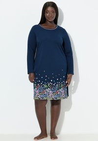 Camicia da notte a maniche lunghe blu navy con scollo rotondo, caratterizzata da una stampa floreale in vari colori vicino all'orlo. Tessuto morbido e confortevole.