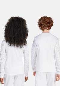 Witte langemouwen shirts met gestructureerde mouwen, voorzien van een geometrisch patroon, ontworpen voor comfort en actieve kleding.