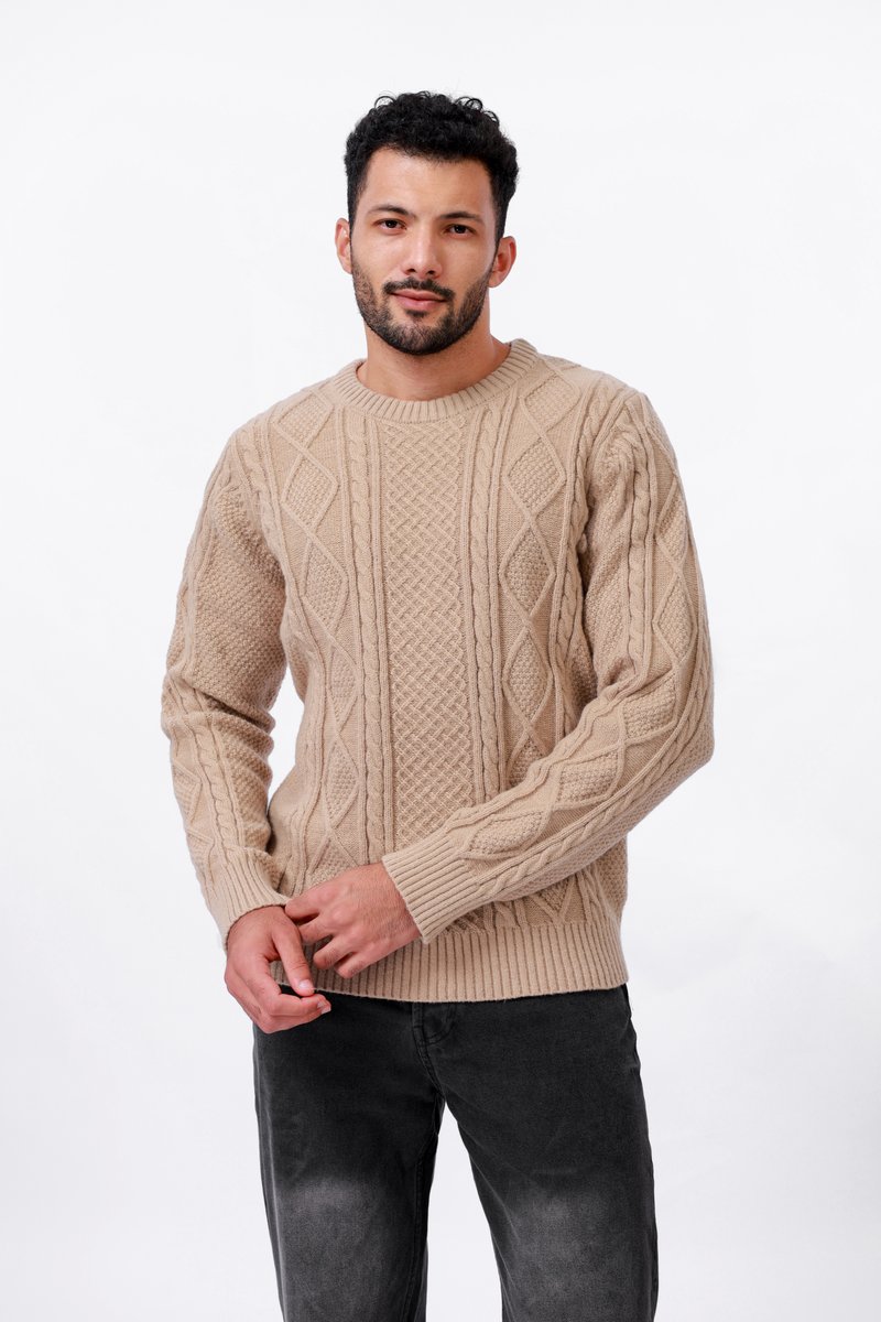 Pull en tricot beige à col rond et à poignets côtelés, présentant des motifs en diamond et texturés sur l'ensemble. Assorti avec un jean gris foncé.