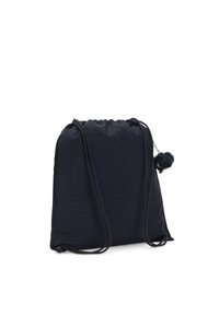 Mochila con cordón en tela azul marino, con una textura suave y forma redondeada; incluye un acento de pompón y cuerdas negras delgadas.