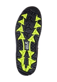 Semelle de chaussure de randonnée noire avec des motifs de crampons angulaires jaunes vifs et le logo Jack Wolfskin au centre.