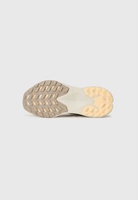 Semelle de chaussure avec une surface en caoutchouc gris texturé, présentant un design de semelle à motifs et une semelle intermédiaire blanc cassé avec des accents beige.