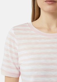Korte mouw t-shirt in lichtroze met witte horizontale strepen, met een ronde hals en een zachte textuur.