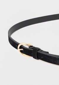 Schwarzer Wildledergürtel mit glatter Oberfläche, ausgestattet mit einer goldfarbenen Metallschnalle und einer Schlaufe zur Verstellung. Einfaches, elegantes Design ohne Verzierungen.