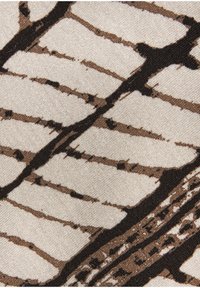 Fabric close-up showing abstract brown and black lines on a beige background with a textured weave pattern.