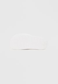 Λευκό πέλμα από καουτσούκ σανδάλου με υφασμένο μοτίβο πλέγματος. Διαθέτει κυκλικό λογότυπο και ελαφρώς ανυψωμένη φτέρνα για καλύτερη πρόσφυση.