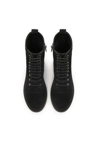 Cizme din suede negre, la glezna, cu șireturi în față, ochiuri din argint și fermoar pe lateral. Talpă din cauciuc cu finisaj texturat.