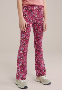 Leggings cu model floral roz, prezentând o combinație de flori în nuanțe de mov și negru, realizate dintr-un material elastic, cu un croi evazat pentru confort.