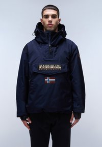 Námořnická modrá anorak bunda s velkou přední kapsou, která má logo a nášivku norské vlajky. Voděodolný materiál, nastavitelné kapuce a manžety.